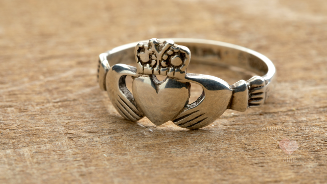 Close-up of a traditional Irish Claddagh ring in silver on a wooden surface